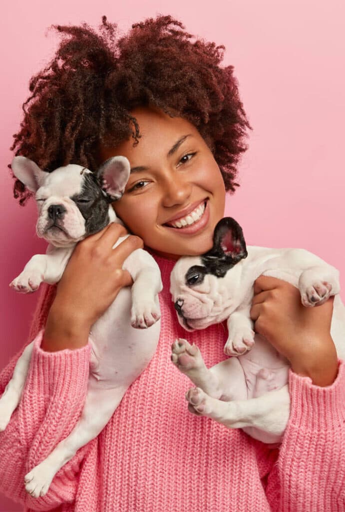 Woman holding two French Bulldog puppies